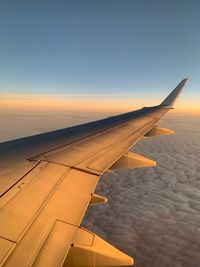 Airplane flying in sky at sunset