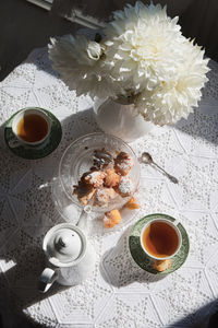 English style tea break, still life with flowers and donuts in the morning sun