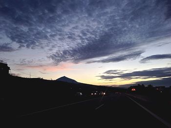 Road against cloudy sky at dusk