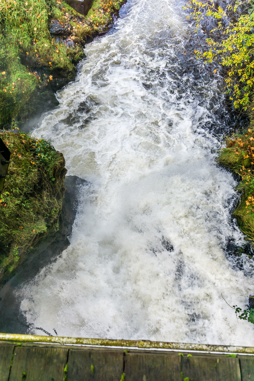 HIGH ANGLE VIEW OF WATER FLOWING OVER ROCKS
