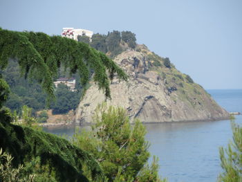 Scenic view of sea and mountains against clear sky