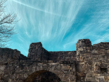 Low angle view of rocks against blue sky