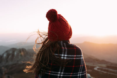 Rear view of woman looking at mountain against sky