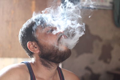 Close-up of young man smoking on water