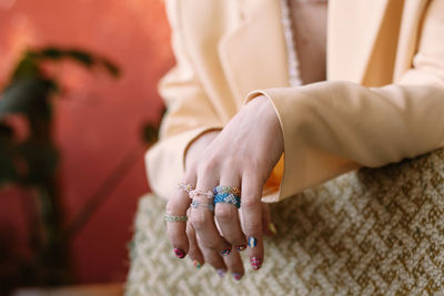 Cropped picture young woman hands with beads rings and stylish decor nails polish