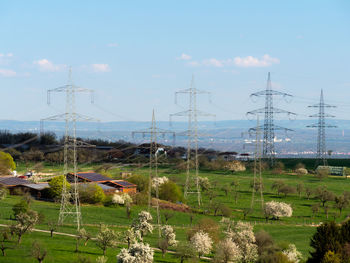 Electricity pylon on field against sky