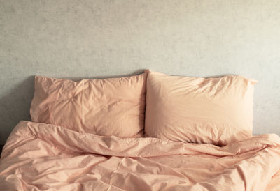 Bed linen peach fuzz color on the background of a gray wall