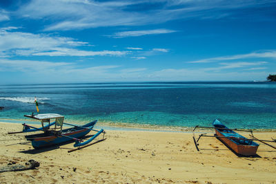 Fishing boat on beach against sky