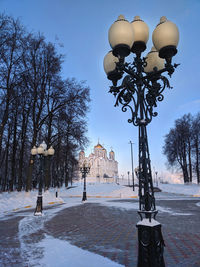 Street light by trees against sky during winter