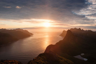 Scenic view of sea and mountains against sky during sunset