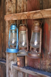 Close-up of lantern hanging on wooden wall