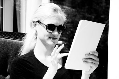 Portrait of woman holding sunglasses