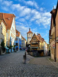 Footpath amidst buildings in  old town against sky