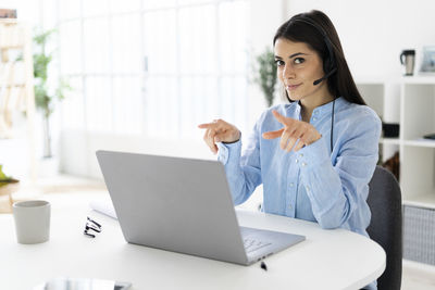 Woman using mobile phone while sitting on table