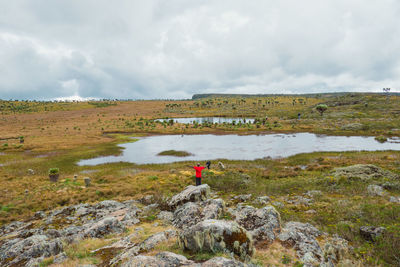 A hiker standing next to a water pond in the 7 ponds hiking trail of aberdare national park,