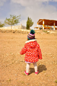 Rear view of girl standing on field