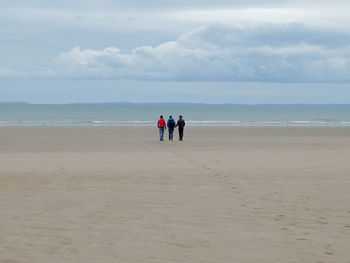 People on beach against sky