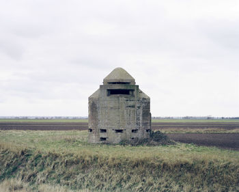 Abandoned built structure on field against sky