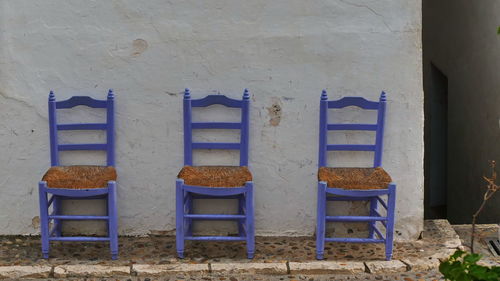 Empty chairs and tables against wall