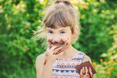 Young woman blowing bubbles while standing against plants