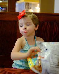 Cute girl looking away while sitting at table