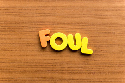 High angle view of colorful foul text on wooden table