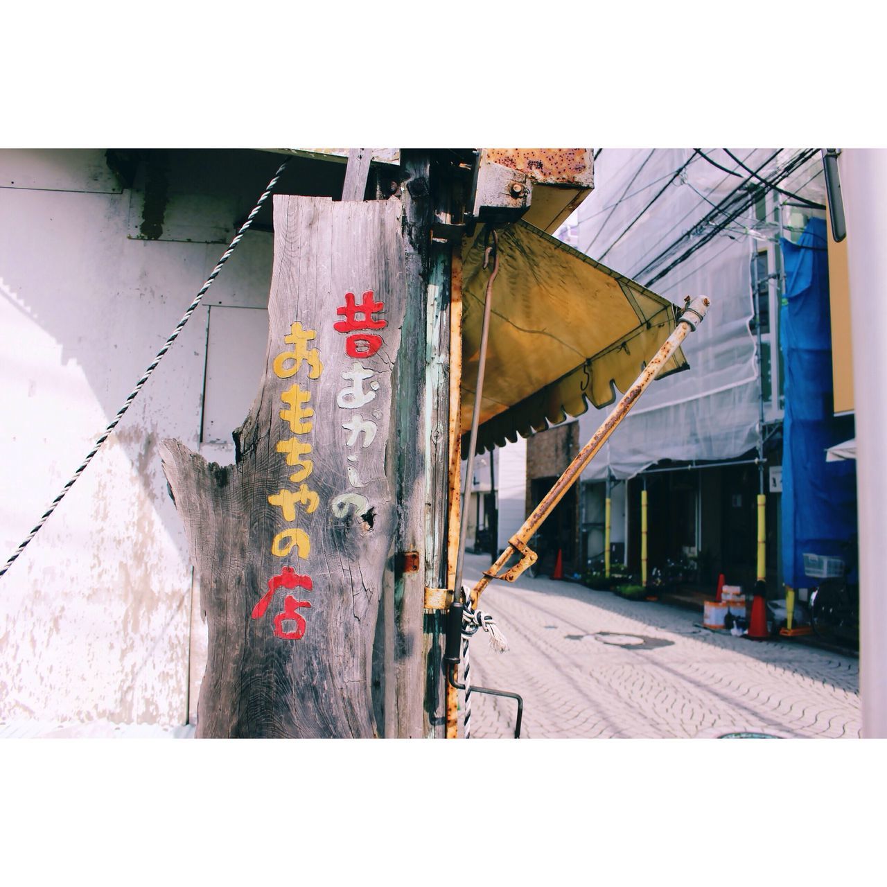 architecture, built structure, building exterior, transfer print, auto post production filter, low angle view, house, building, graffiti, day, sky, outdoors, abandoned, no people, damaged, sunlight, clear sky, power line, wall - building feature, transportation