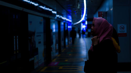 Rear view of woman walking in tunnel jakarta mrt