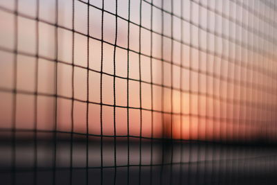 Full frame shot of metal fence against sky during sunset