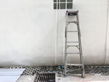 Empty ladder against wall of building
