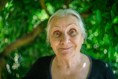 Portrait of senior woman against tree