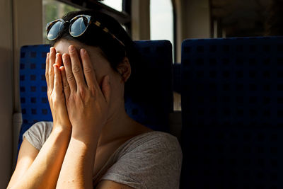 Woman covering face in train