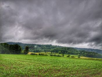 Scenic view of field against cloudy sky