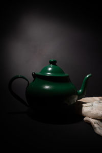 Close-up of tea cup on table against black background