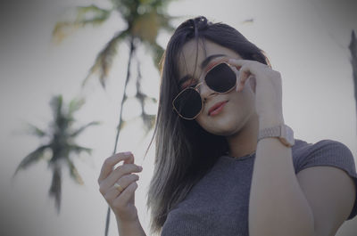 Portrait of a young woman drinking sunglasses