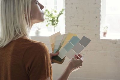 Young woman in a loft thinking about color samples