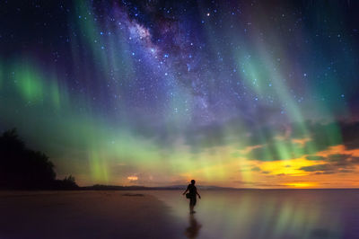 Silhouette man standing against star field at night