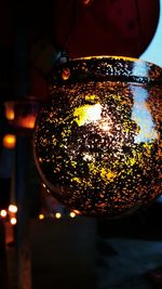 Close-up of illuminated lighting equipment hanging at night