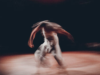 Blurred motion of man dancing on stage