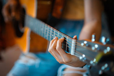 Midsection of woman playing guitar