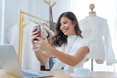 Young woman using phone on table