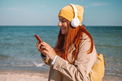 Young woman using mobile phone at beach