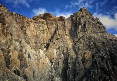 Low angle view of rocky mountains against sky