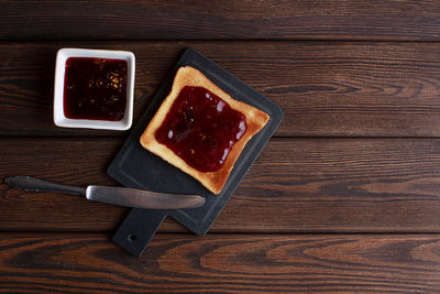 Toasts with jam on dark wooden table