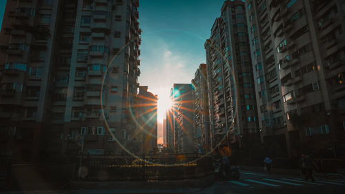 Street amidst buildings against sky during sunset