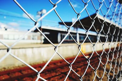 Close-up of chainlink fence against blue sky