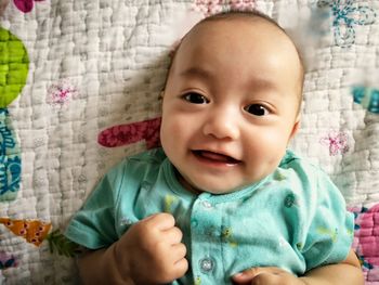 Portrait of cute baby girl lying down on bed