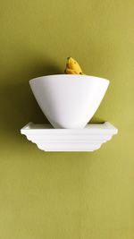 Close-up of yellow bowl over white background