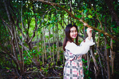 Portrait of young woman standing in forest