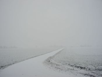 Snow covered landscape against sky